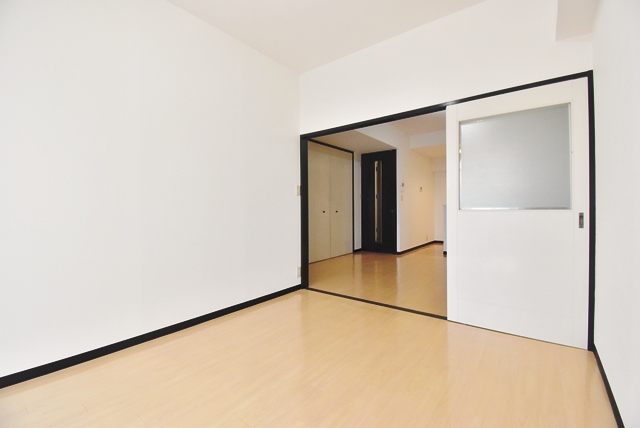 洋室部分。2020年床面フロアタイル貼付。2025年9月、壁・天井クロス張替済。仕切戸を外したら、約16帖のLDKとしても使用できます。